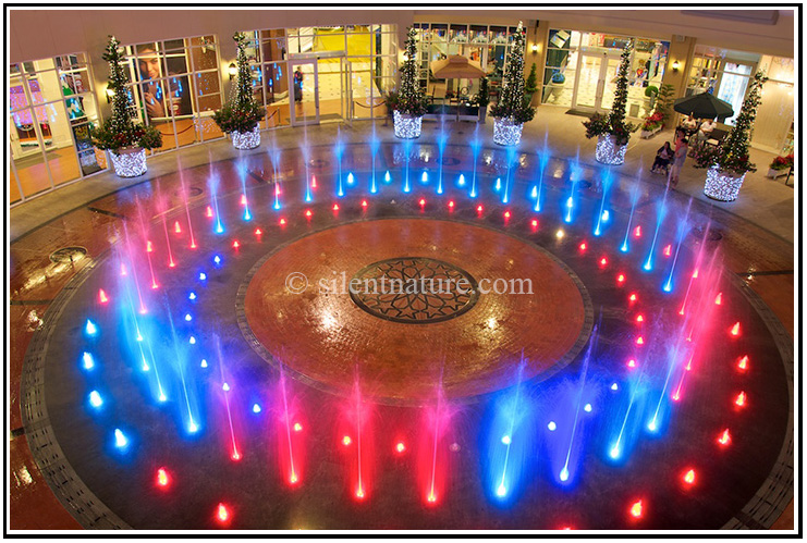 The water fountain as viewed from above with red and blue lights.