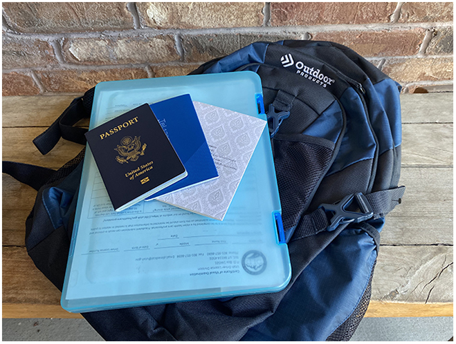 A photo of a backpack on a wooden bench with a passport and other documents displayed.