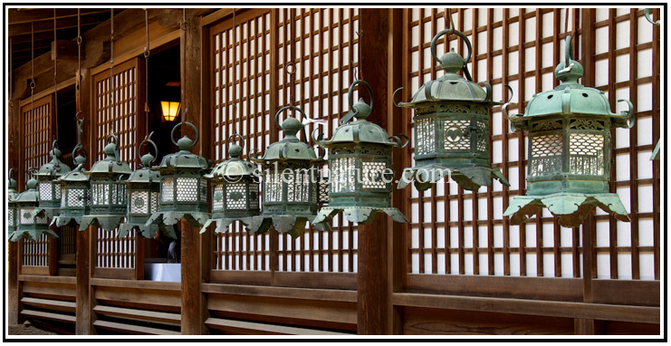 Ancient Japanese lanterns line up along the wall of the temple.