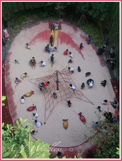 A beautiful ariel view of children playing on the sand of a playground.
