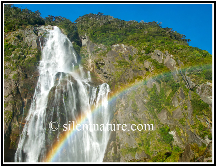 A rainbow swipes across this beautiful waterfall.