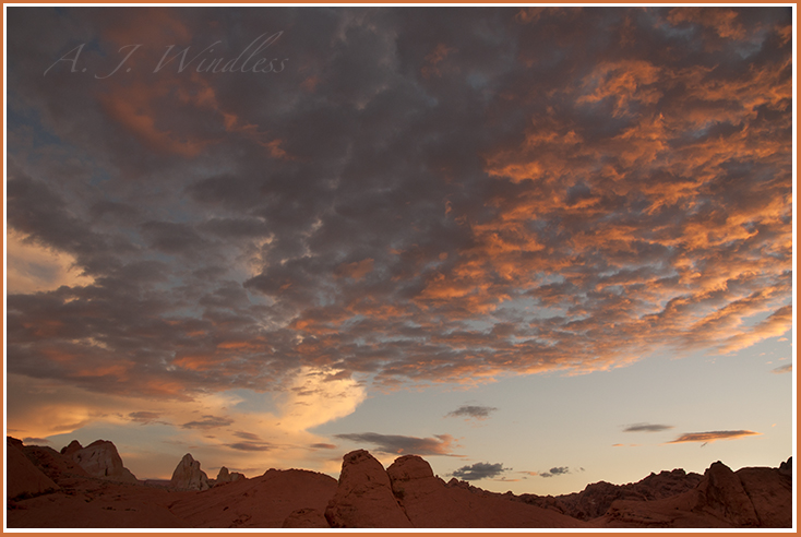 Clouds painted with the colors of sunset fan out over Valley of Fire State Park.