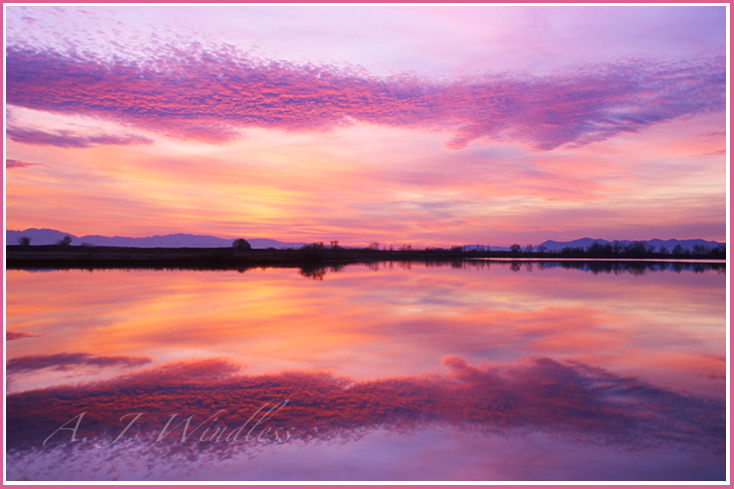 Stunning sunset clouds reflected perfectly in the water of a small lake near the Great Salt Lake.